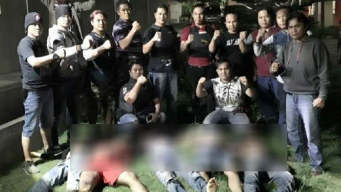 Foto 13 polisi Lampung di depan lima mayat yang bergelimpangan di tanah.