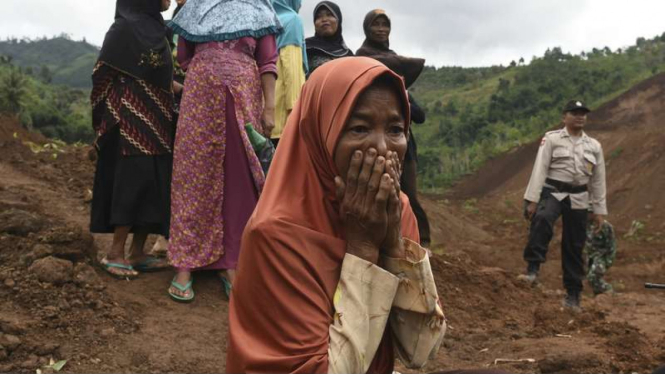 Keluarga korban menyaksikan tim SAR gabungan mencari korban yang tertimbun longsor di Desa Banaran, Kecamatan Pulung, Ponorogo, Jawa Timur, Senin (3/4/2017).