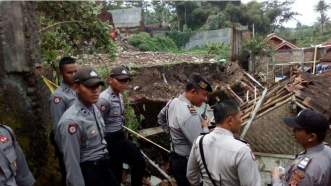 Petugas polisi melakukan oleh tempat kejadian perkara di lokasi robohnya tembok pabrik sepanjang 20 meter di Kabupaten Garut Jawa Barat, Rabu (5/4/2017)