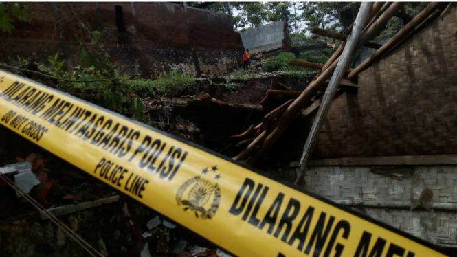 Polisi memasang garis pengaman di tempat kejadian perkara. 