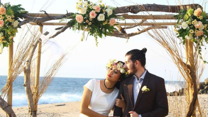 Sepasang kekasih menikah di pinggir pantai. 