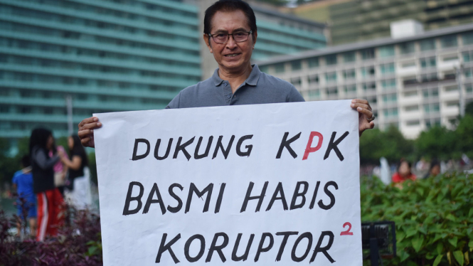 Aktor senior Pong Harjatmo melakukan aksi dengan membawa poster ketika pelaksanaan Hari Bebas Kendaraan Bermotor di Kawasan Bundaran HI Jakarta.