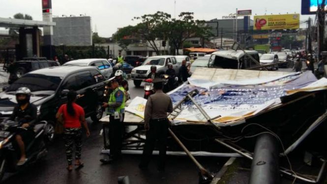 Sebuah tiang papan reklame roboh akibat dihempas hujan-badai lalu menimpa mobil travel penuh penumpang di Bandung, Jawa Barat, pada Rabu siang, 19 April 2017.