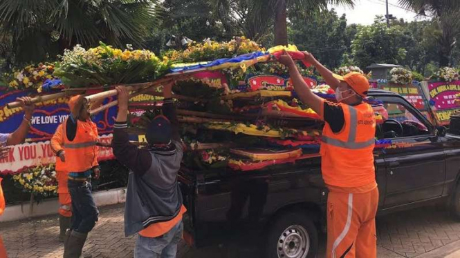 Petugas memindahkan karangan bunga untuk Ahok ke Monas, Kamis, 27 April 2017.