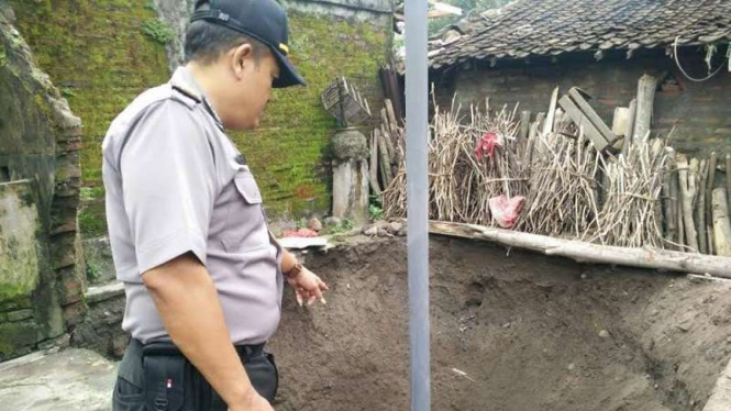 Petugas kepolisian memeriksa kondisi sumur  yang ambles di Kabupaten Kediri