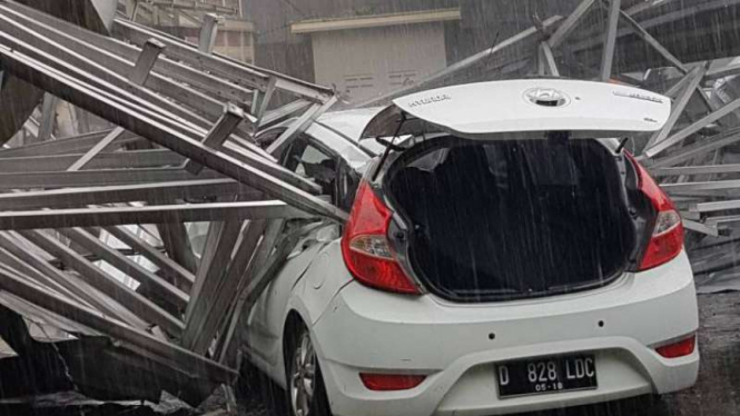 Salah satu mobil tertimpa atap bangunan sekolah di Bandung saat hujan disertai angin kencang.