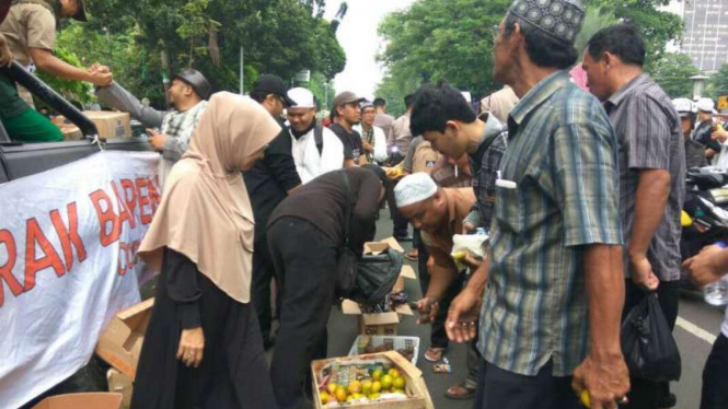 Sebagian massa aksi 505 membagikan buah-buahan gratis, Jumat, 5 Mei 2017.