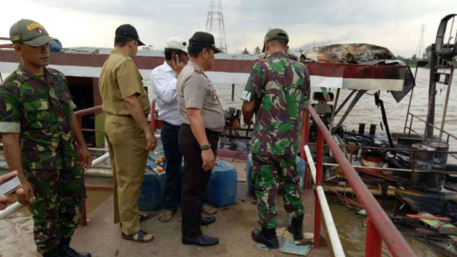 Aparat memeriksa stasiun pengisian bahan bakar terapung di aliran Sungai Musi, Kabupaten Banyuasin, Sumatera Selatan, setelah meledak dan membakar dua kapal jukung pada Senin, 15 Mei 2017.