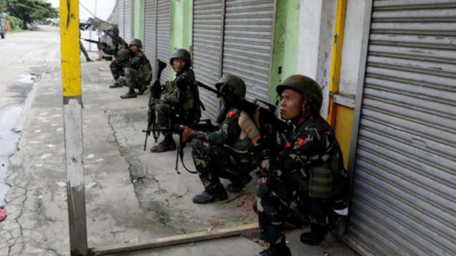 Militer Filipina berjaga di depan toko-toko yang tutup di kota Marawi.