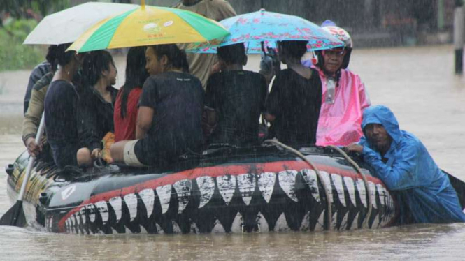 Warga korban banjir dievakuasi dengan perahu karet di Kota Padang, Sumatera Barat, pada Rabu, 31 Mei 2017.