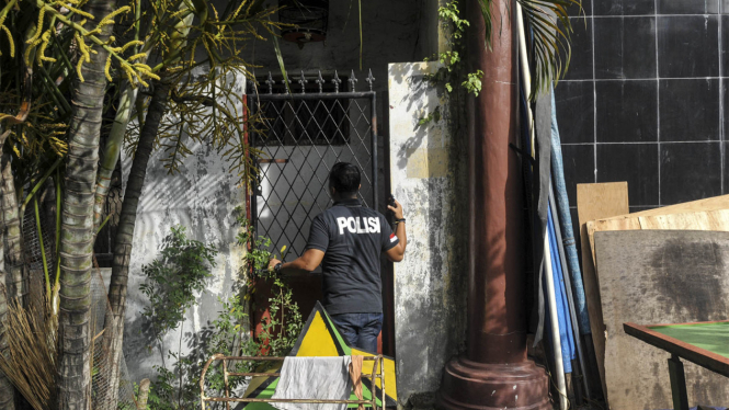 Seorang polisi saat menggerebek sebuah rumah di Jakarta beberapa waktu lalu. 