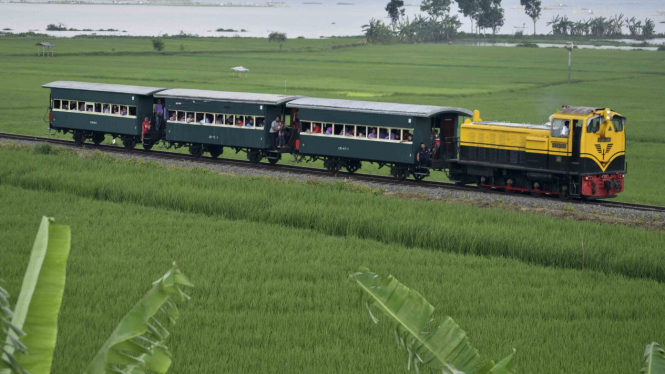 Rangkaian kereta api kuno membawa sejumlah wisatawan melintasi kawasan Rawa Pening di Bawen, Kabupaten Semarang, Jawa Tengah