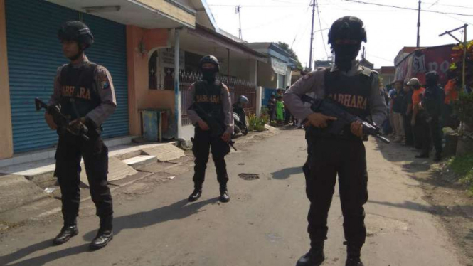 Aparat Polres Malang menjaga sebuah rumah seorang terduga teroris yang digeledah setelah penangkapan oleh Densus 88 Antiteror pada Senin, 19 Juni 2017.