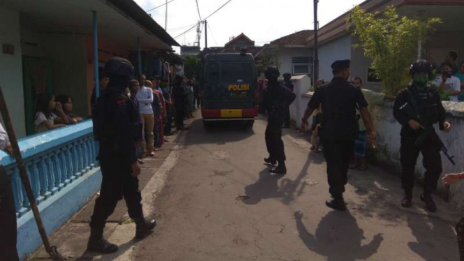 Aparat Polres Malang menjaga sebuah rumah seorang terduga teroris yang digeledah setelah penangkapan oleh Densus 88 Antiteror pada Senin, 19 Juni 2017.