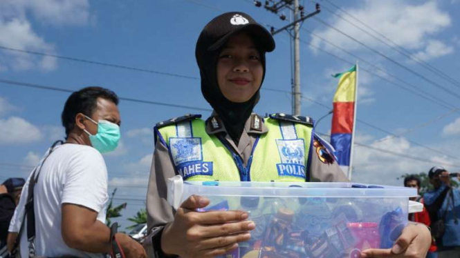 Polwan Polres Karanganyar membagi-bagikan minuman kemasan kaleng dan makanan ringan kepada pemudik di Tol Solo-Ngawi pada Kamis, 22 Juni 2017.