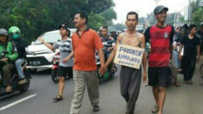 Seorang pria tersangka pencabulan diarak warga menuju kantor polisi di Depok, Jawa Barat, pada Kamis, 22 Juni 2017.