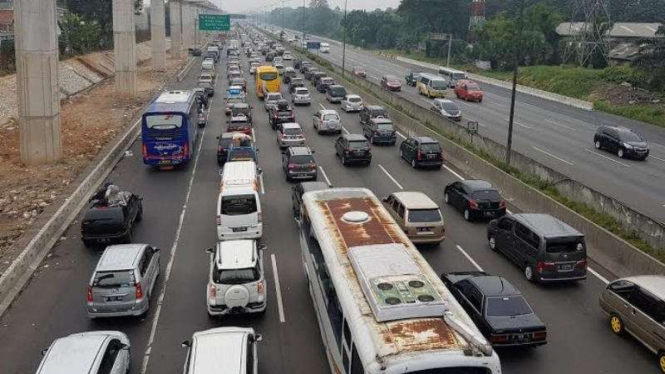 Antrian panjang di Tol Jakarta Cikampek. Kendaraan bergerak sangat perlahan.