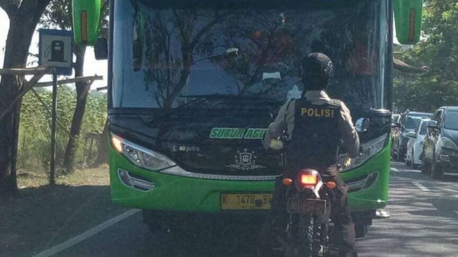 Aksi polisi bermotor mengadang bus yang melawan arus di Mojokerto, Jawa Timur.