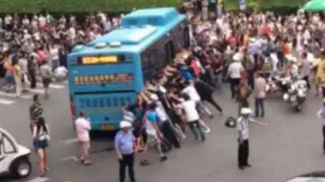 Warga ramai-ramai tolong kakek yang terjepit di kolong bus.