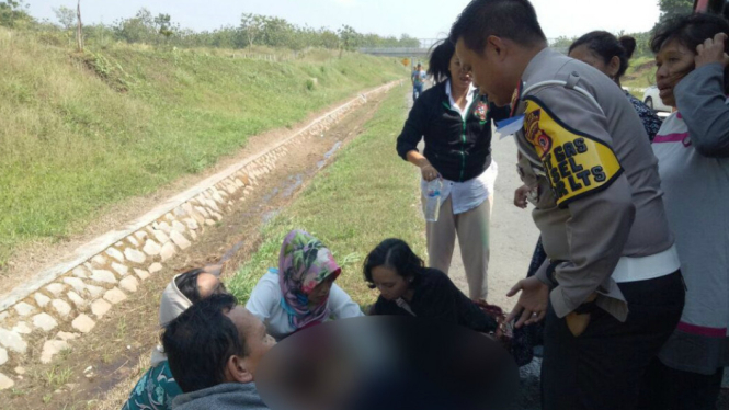 Petugas Polres Purwakarta bersama penumpang bantu ibu melahirkan di pinggir tol
