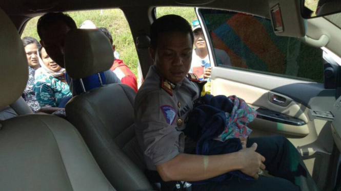 Petugas Polres Purwakarta bersama penumpang bantu ibu melahirkan di pinggir tol.