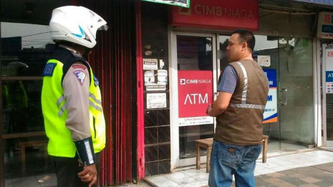 Petugas kepolisian memeriksa lokasi ATM CIMB Niaga yang nyaris dibongkar.