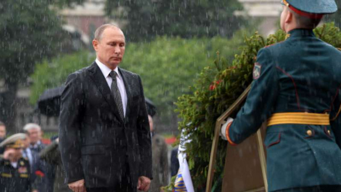 Presiden Rusia, Vladimir Putin, tegap berdiri meski diguyur hujan dalam upacara peringatan pahlawan tak dikenal dalam melawan pendudukan Nazi di Perang Dunia Kedua.