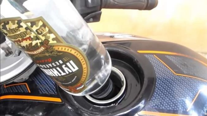 Minuman keras dituang ke dalam tangki motor.