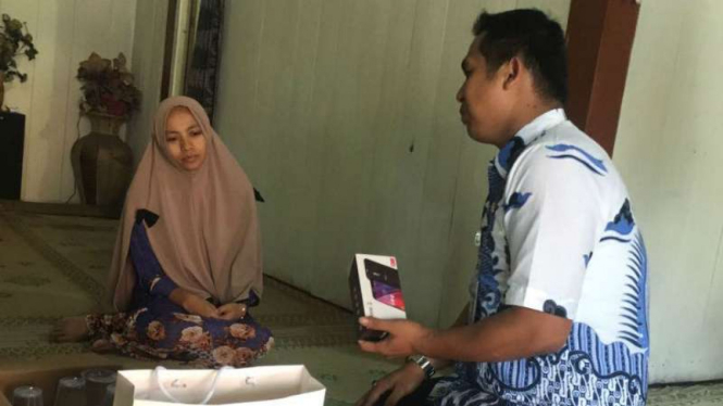 Utusan Gubernur Jawa Tengah Ganjar Pranowo saat memberikan ponsel kepada istri almarhum Nyoto Purwanto, korban helikopter jatuh, yang akan diberikan kepada ibu korban.