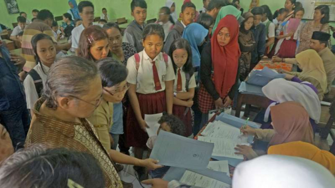 Calon siswa beserta wali murid antre pendaftaran penerimaan peserta didik baru (PPDB) SMP melalui sistem zonasi di SMPN 2 Tulungagung, Tulungagung, Jawa Timur, Senin (12/6/2017).