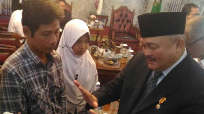 Gubernur Sumatera Selatan Alex Noerdin (kanan) berbincang dengan seorang ayah yang mau menjual organ ginjalnya untuk biaya sekolah anaknya di Palembang pada Senin, 10 Juli 2017.