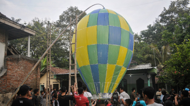  Warga menerbangkan balon udara di Desa Bandung, Kecamatan Diwek, Kabupaten Jombang, Jawa Timur, Minggu (2/7). Tradisi menerbangkan balon udara raksasa bersamaan di tiap musholah ini untuk merayakan Lebaran Ketupat atau biasa disebut Kupatan.