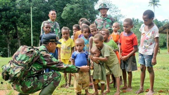 Anggota TNI AD saat di daerah perbatasan Papua bertatap muka dengan anak-anak di desa.