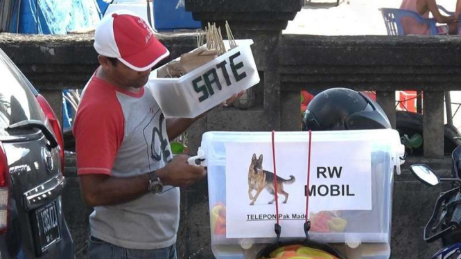 Salah seorang penjaja sate daging anjing di Bali yang menjual dagangannya di kawasan objek wisata Bali.