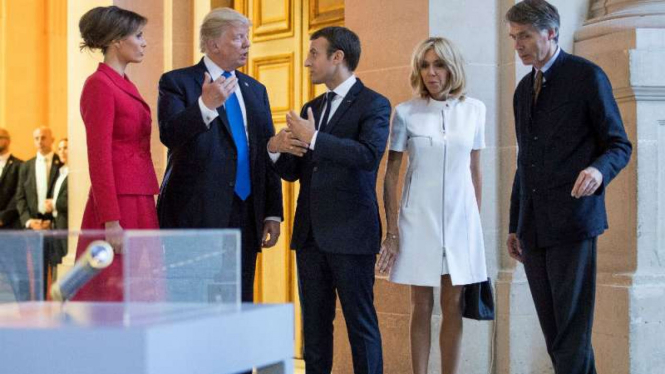 Presiden Prancis, Emmanuel Macron, menyambut kunjungan Presiden AS, Donald Trump, dan istrinya di Paris.