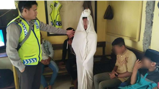 Sosok pocong yang kerap menghantui warga dan pengendara di Jalur Trans Sulawesi saat dibekuk kepolisian.