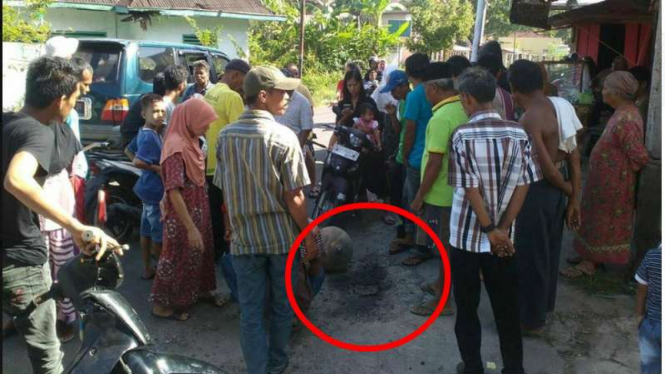 Warga menyaksikan benda langit misterius yang terjatuh di jalan raya Jorong Kubu Kabupaten Agam Sumatera Barat, Selasa (18/7/2017)