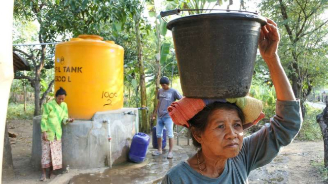 Warga membawa ember berisi air di Desa Curahtatal, Arjasa, Situbondo, Jawa Timur, Kamis (20/7/2017).