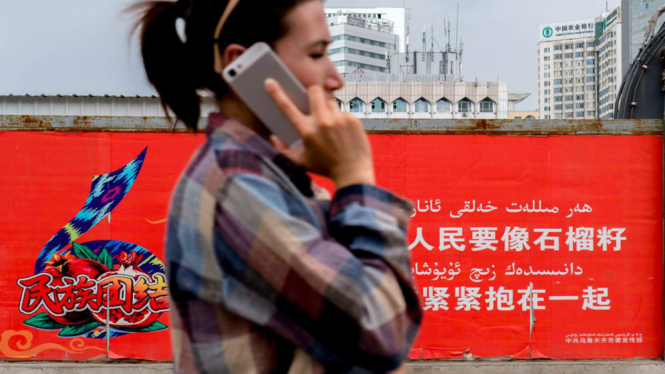 Seorang pengguna ponsel wanita etnis Uyghur di Xinjiang