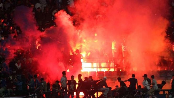 Suporter Persib Bandung menyalakan suar di tribun.