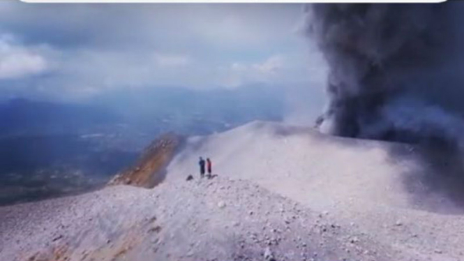 Dua turis berada di puncak Gunung Sinabung