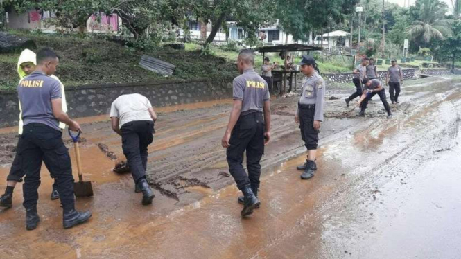 Sejumlah personel kepolisian di Kota Jayapura bergotong royong membersihkan sisa material banjir di daerah itu, Kamis (3/8/2017)