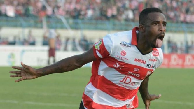 Pemain Madura United, Greg Nwokolo, melakukan selebrasi gol.