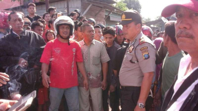 Warga dan polisi saat di lokasi kejadian pembunuhan seorang pemuda di jalan padat lalu lintas Kota Medan Sumatera Utara, Senin (7/8/2017)