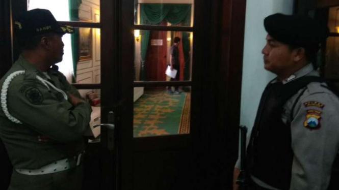 Aparat Polisi dan Satpol PP menjaga pintu ruangan Wali Kota Malang saat tim KPK menggeledah ruangan itu pada Rabu, 9 Agustus 2017.