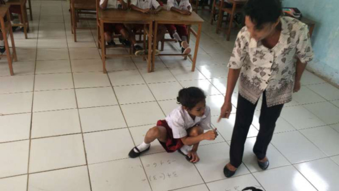 Para siswa dan guru di SD Piliana Kecamatan Tehoru, Kabupaten Maluku, beraktivitas belajar-mengajar tanpa papan tulis sehingga terpaksa menulis di lantai ubin.