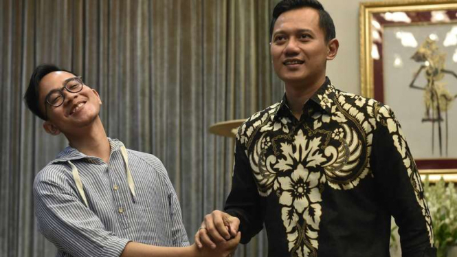 Putra Presiden Joko Widodo, Gibran Rakabuming Raka, berjabat tangan dengan Agus Harimurti Yudhoyono di Kompleks Istana Kepresidenan.