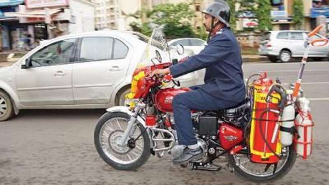 Pemadam kebakaran dengan motor Royal Enfield.