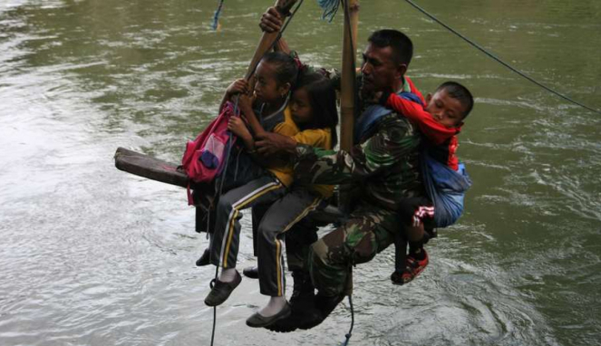 Serka Darwis membantu sejumlah pelajar untuk menyeberangi Sungai Ranteangin di Desa Maroko Kolaka Utara Sulawesi Tenggara.