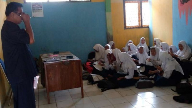 Siswa madrasah belajar di lantai.